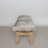 end view of a mottled grey cowhide bench or ottoman