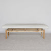 frot view of the cream coloured cowhide ottoman bench on a teak wood base by corcovado