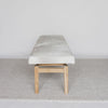 end view of a cream and grey cowhide ottoman bench seat from corcovado