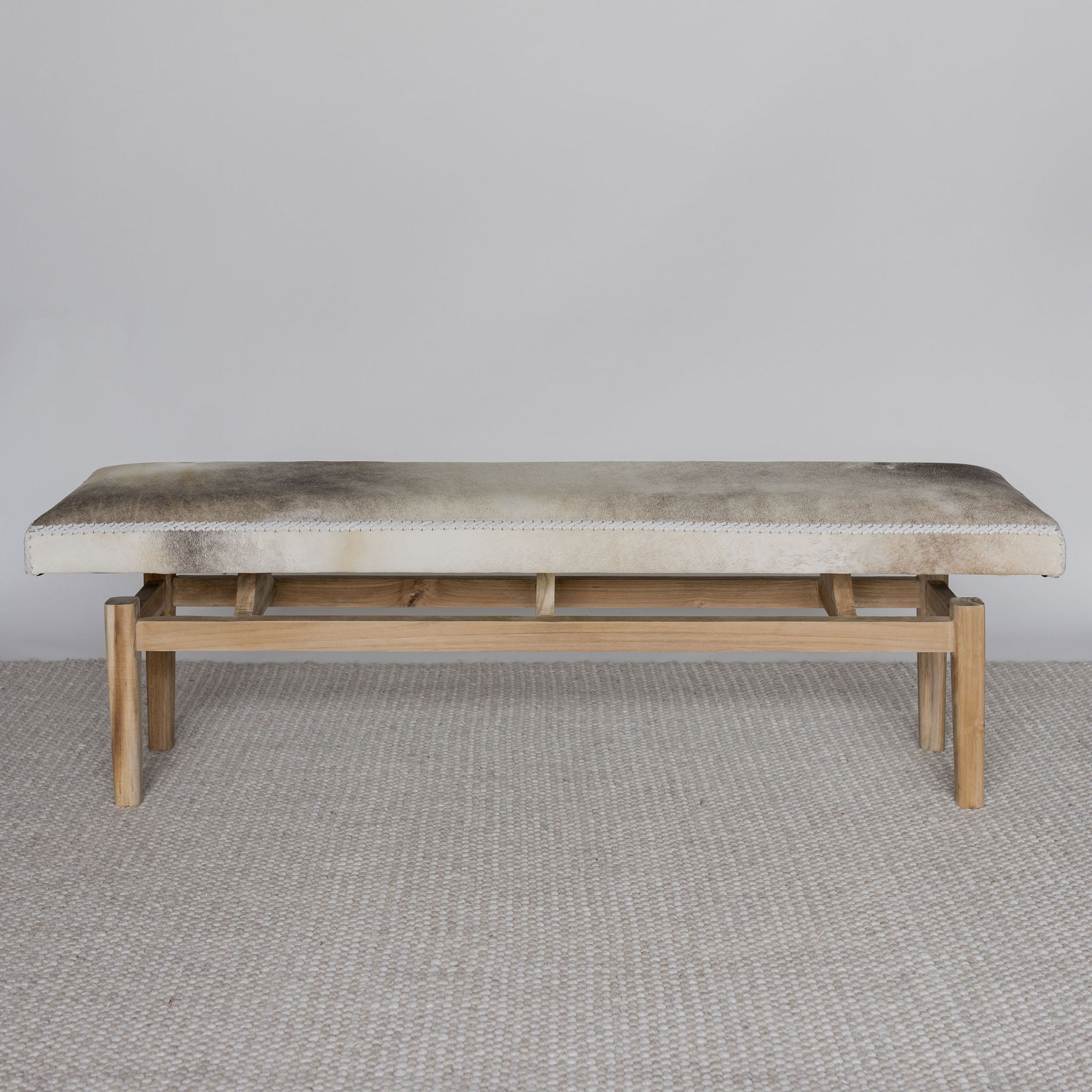 front view of a cowhide bench seat in cream and grey tones from corcovado 