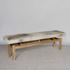 angled view of a cowhide bench seat in cream and grey tones from corcovado