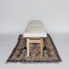 end view of a modern cream coloured cowhide bench seat ottoman on top of a turkish rug