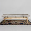 front view of a modern cream coloured cowhide bench seat ottoman on top of a turkish rug