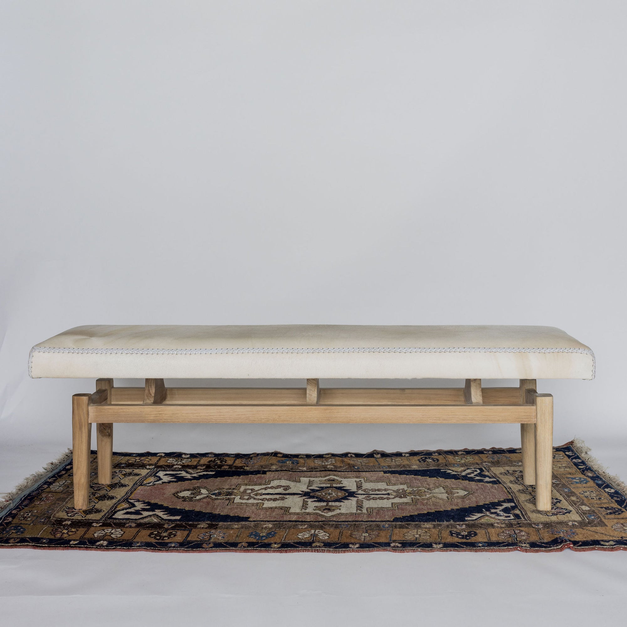 full length view of a creamy coloured narrow entrance bench made from cowhide