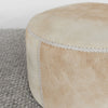 close up view of the stitching on a caramel coloured round cowhide ottoman coffee table by Corcovado