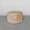 front view of a caramel coloured round cowhide ottoman coffee table by Corcovado