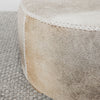 close up angle of the creamy and caramel grey side of round cowhide ottoman coffee table