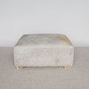 front view of an extra large grey coloured square cowhide ottoman coffee table