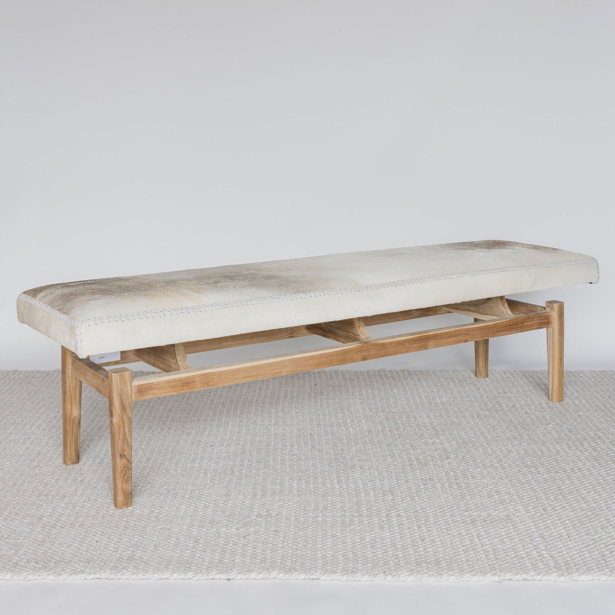 angled view of the grey and cream coloured cowhide bench seat ottoman from Corcovado