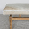 close up view of the end of the long cowhide bench seat with grey and cream coloured cowhide