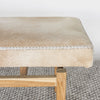 close up end view of a caramel earthy coloured cowhide bench seat