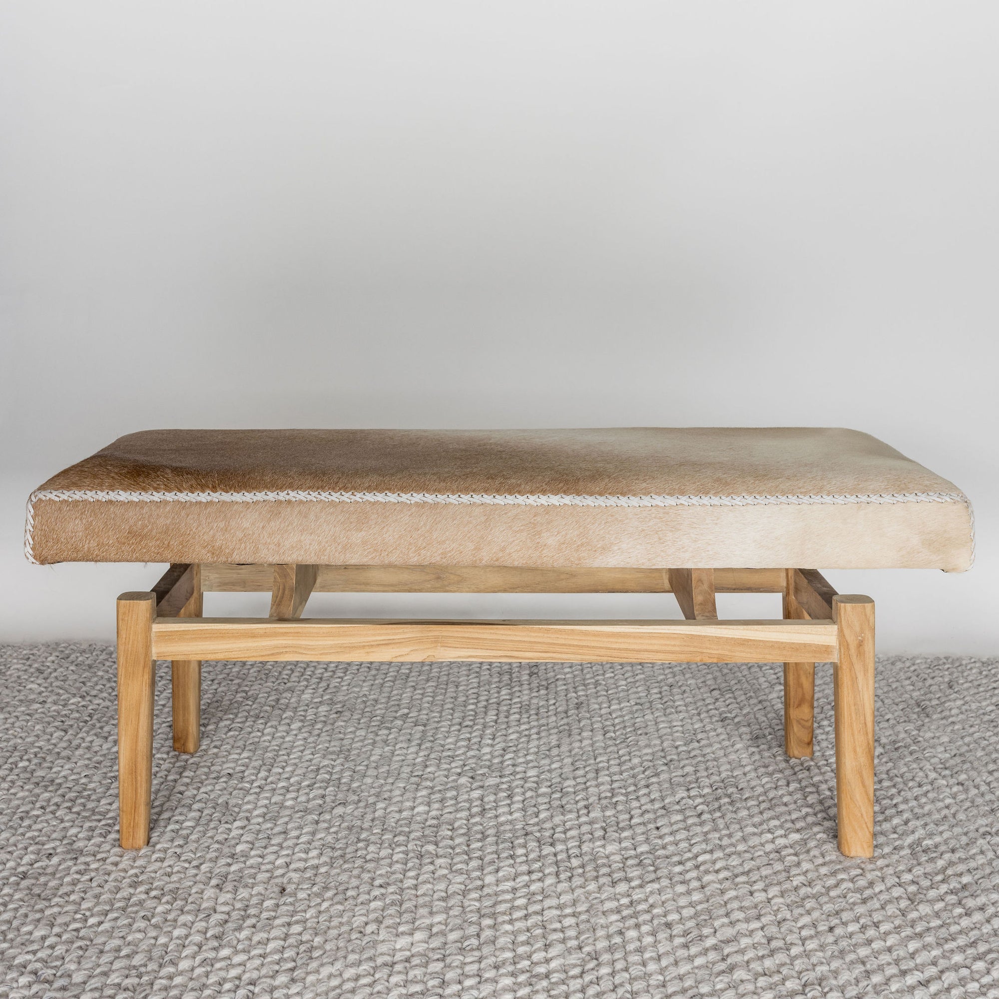 front view of a caramel earthy coloured cowhide bench seat