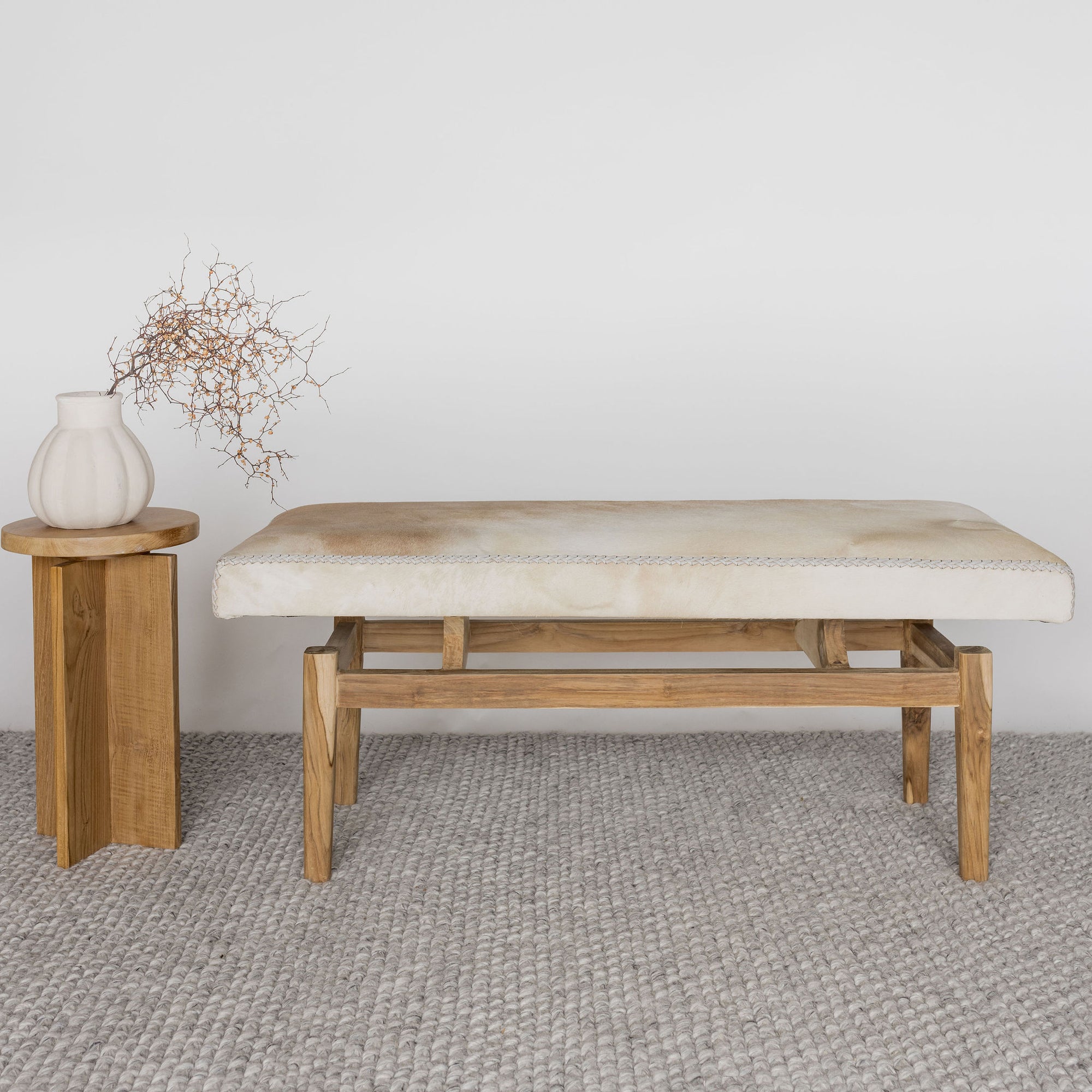 caramel coloured and cream cowhide bench seat with side table