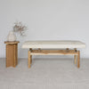 cream coloured cowhide ottoman bench seat next to a small wooden table