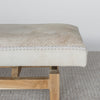 close up end view showing the leather stitching of a cowhide bench seat in cream earthy neutral tones