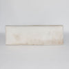 top down view of a cowhide bench seat in cream earthy neutral tones