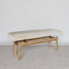 angled view of a cowhide bench seat in cream earthy neutral tones