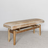 angled view of a of a caramel brown and cream coloured cowhide bench seat by corcovado