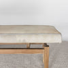 close up end view of a cream coloured cowhide bench seat ottoman