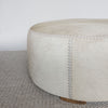 close up of the leather stitching in a large, cream cowhide ottoman coffee table