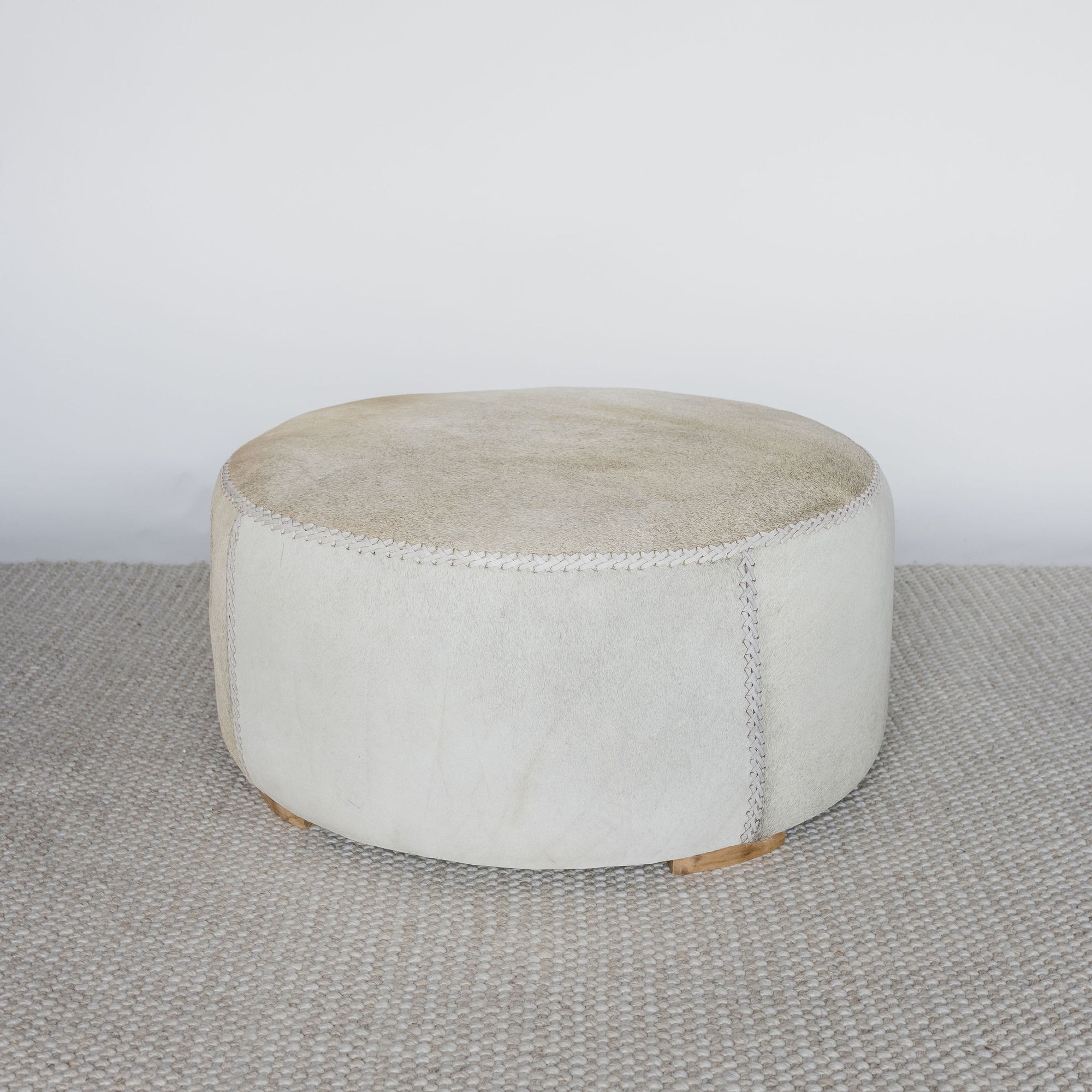 full front view of a round cowhide ottoman coffee table by corcovado