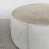 close up view showing the leather stitch detailng on the round cowhide ottoman coffee table by corcovado