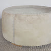 close up view of a cream and grey cowhide round ottoman from corcovado