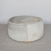 another side view of the cream and grey cowhide round ottoman from corcovado