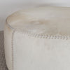 close up view of the cream coloured light cowhide round ottoman coffee table