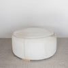 side view of the cream coloured light cowhide round ottoman coffee table