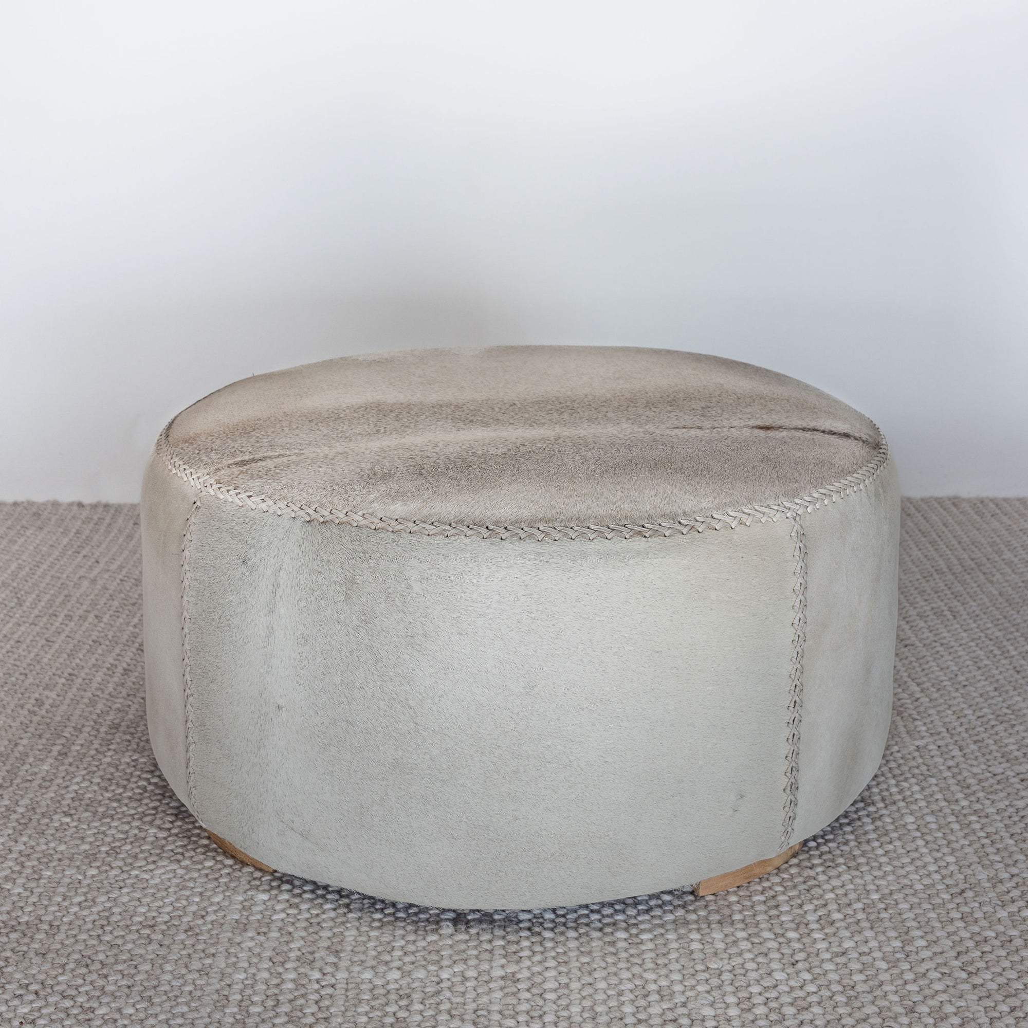 neutral coloured round cowhide ottoman coffee table 