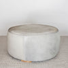 another angle of the round neutral toned natural cowhide ottoman coffee table