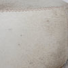 close up of the stitching on the cream coloured round cowhide ottoman coffee table from corcovado