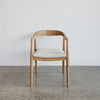 front view of a wooden dining chair with a curved back which is upholstered in fibreguard fabric by Corcovado