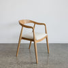 a wooden dining chair with a curved back which is upholstered in fibreguard fabric by Corcovado