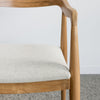 close up of a wooden dining chair with a curved back which is upholstered in fibreguard fabric by Corcovado