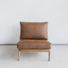 front view of an oversized lounge chair in tan leather like fabric on a teak wood frame