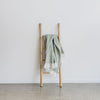 sorrento sage green wool blend throw on a natural bamboo ladder