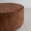 close up of the round velvet floor pouff or ottoman in a rich cinnamon colour with piped edging