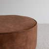 top detail and close up of the round velvet floor pouff or ottoman in a rich cinnamon colour with piped edging