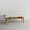 angled view of the soft creamy white cowhide bench ottoman seat from corcovado