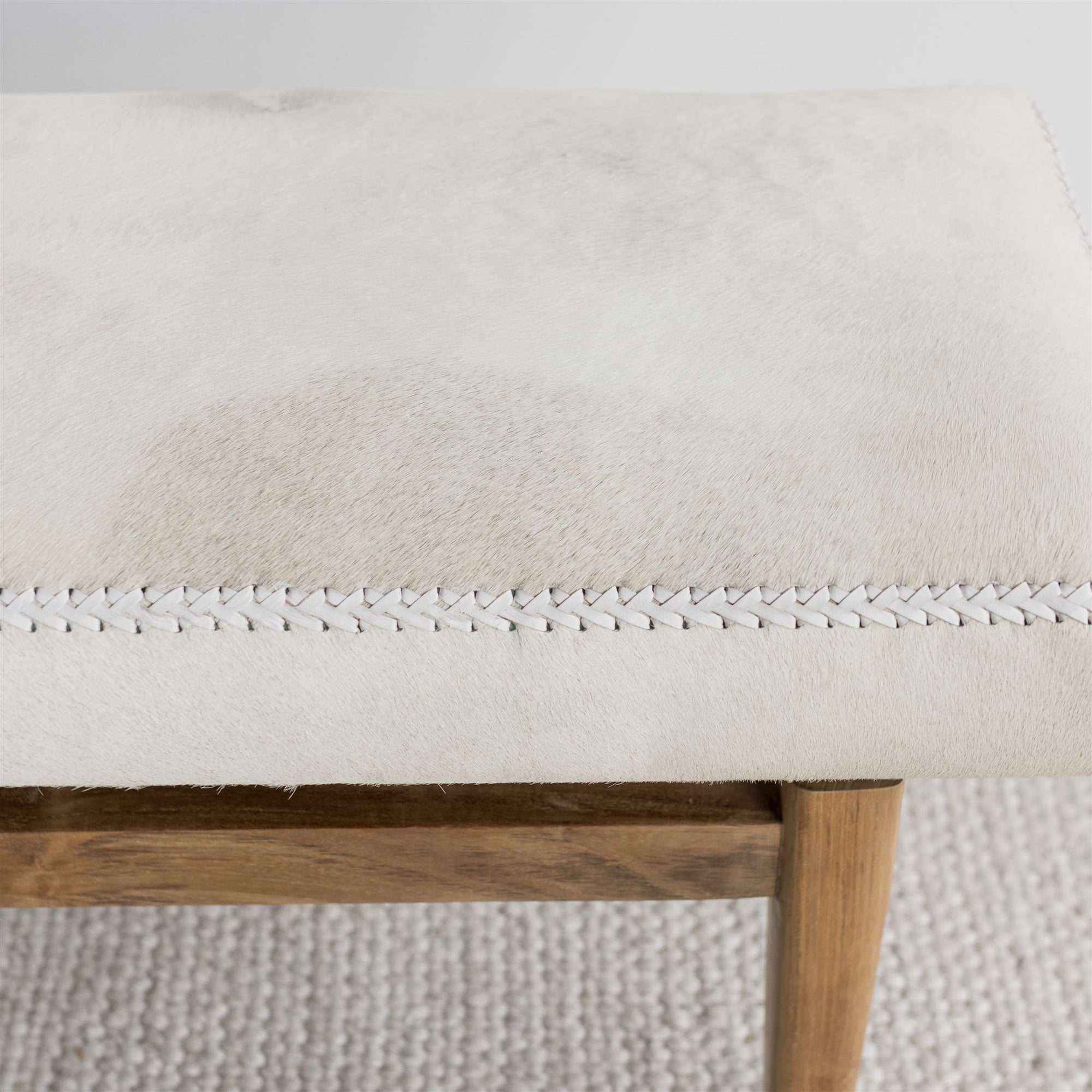 close up of the soft creamy white cowhide bench ottoman seat from corcovado 