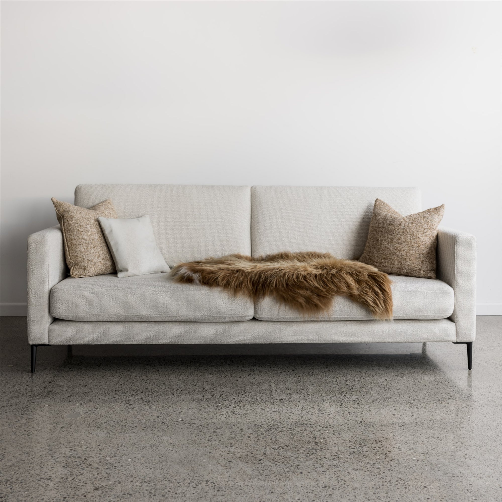 corcovado drift sofa with black metal legs and covered in an icelandic sheepskin