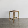 angled view of the woven tan leather bar stool