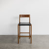 front view of the savanna bar stool with vintage brown wood and black leather seat from Corcovado