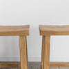 close up pf the set of two light teak wooden chinese style bar stools from corcovado