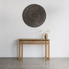 blackwash rattan wall art in 100cm dia above a natural teak wood console.