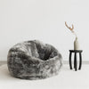 dark grey sheepskin beanbag chair and black african side table